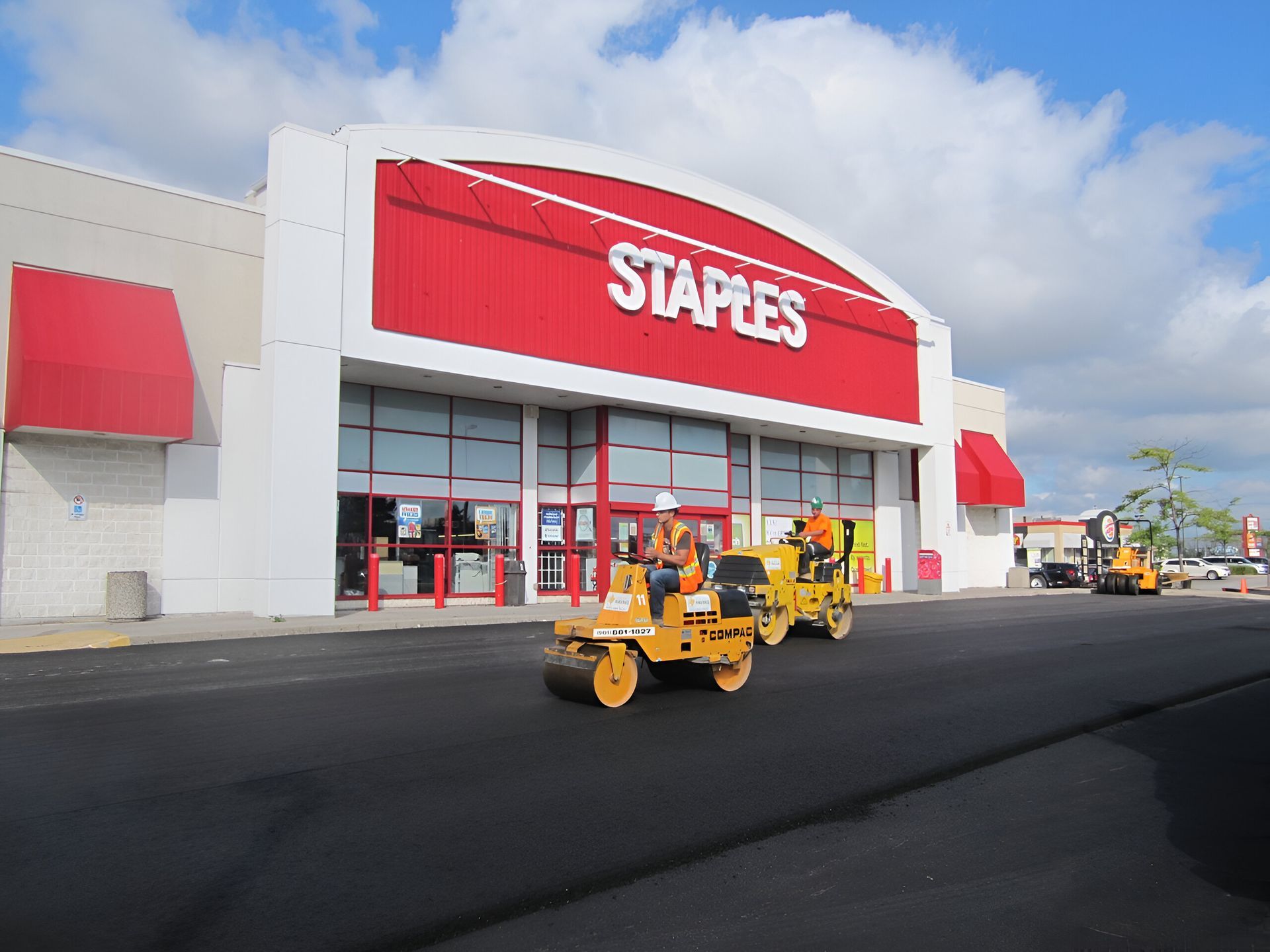 A staples store is being paved with a roller