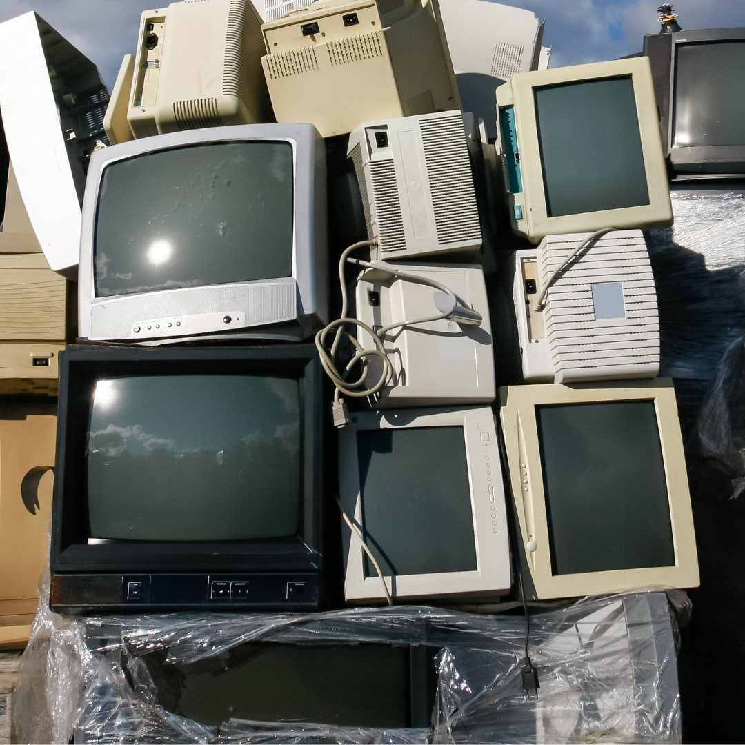 A pile of old computer monitors including one that says ' lg ' on it