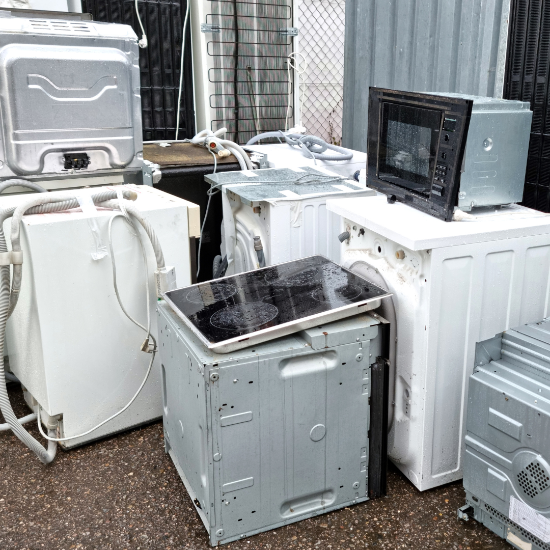 A bunch of old appliances are sitting on the ground.