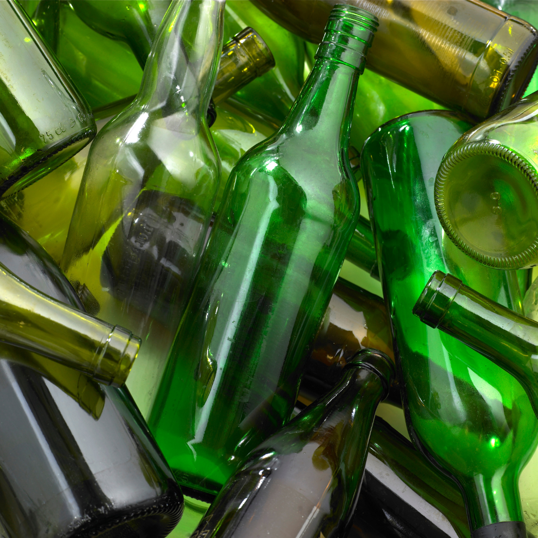 A pile of empty green glass wine bottles
