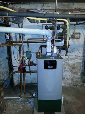 A boiler in a basement with pipes coming out of it