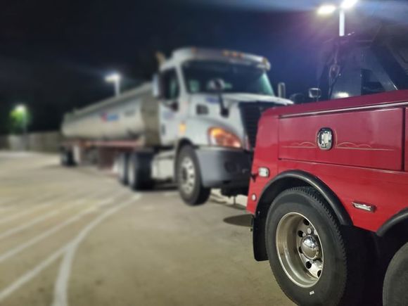A concrete mixer truck is being towed by a forklift.