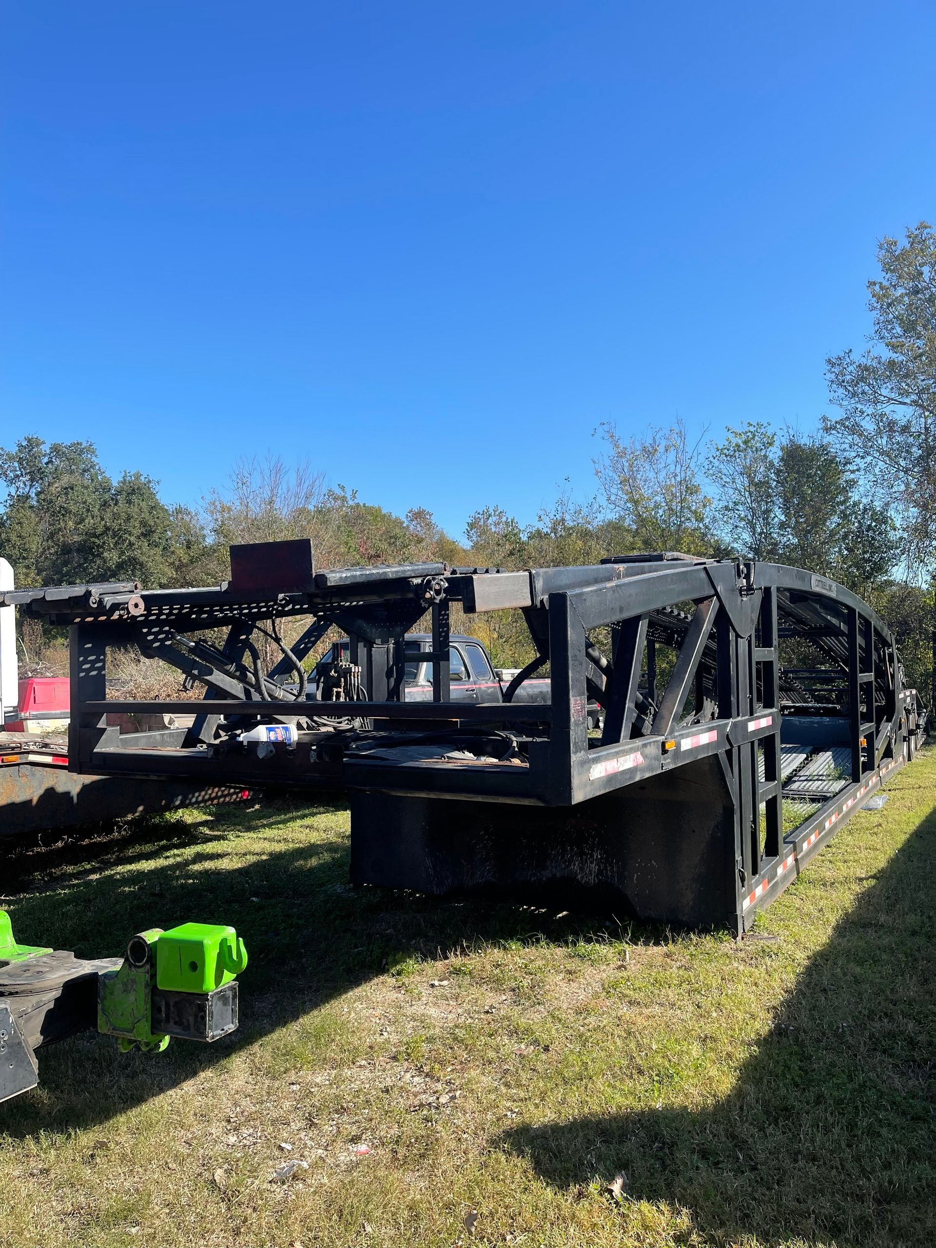 A large metal structure is sitting in the middle of a grassy field.
