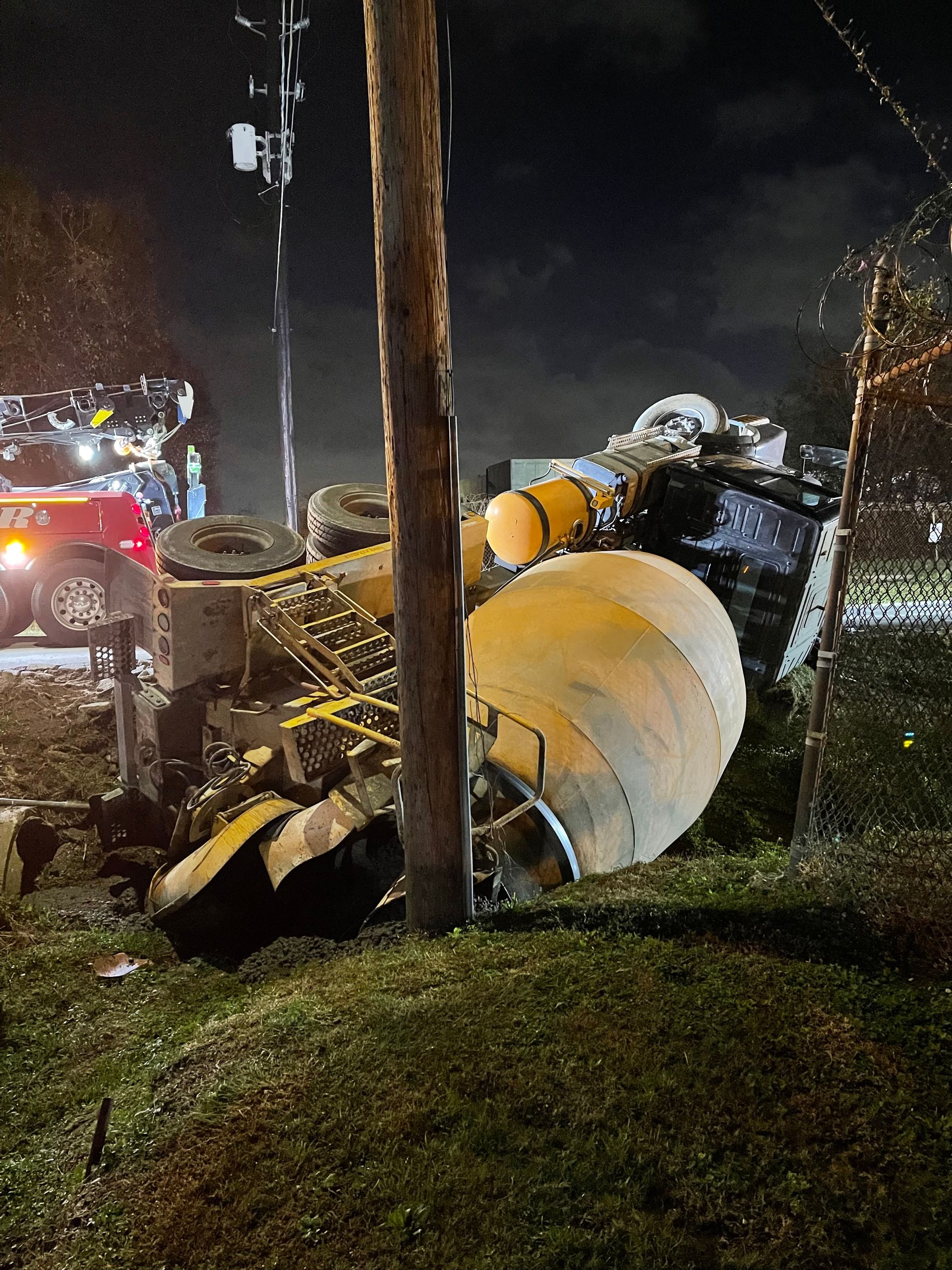 A tow truck is carrying a tractor on a flatbed trailer.