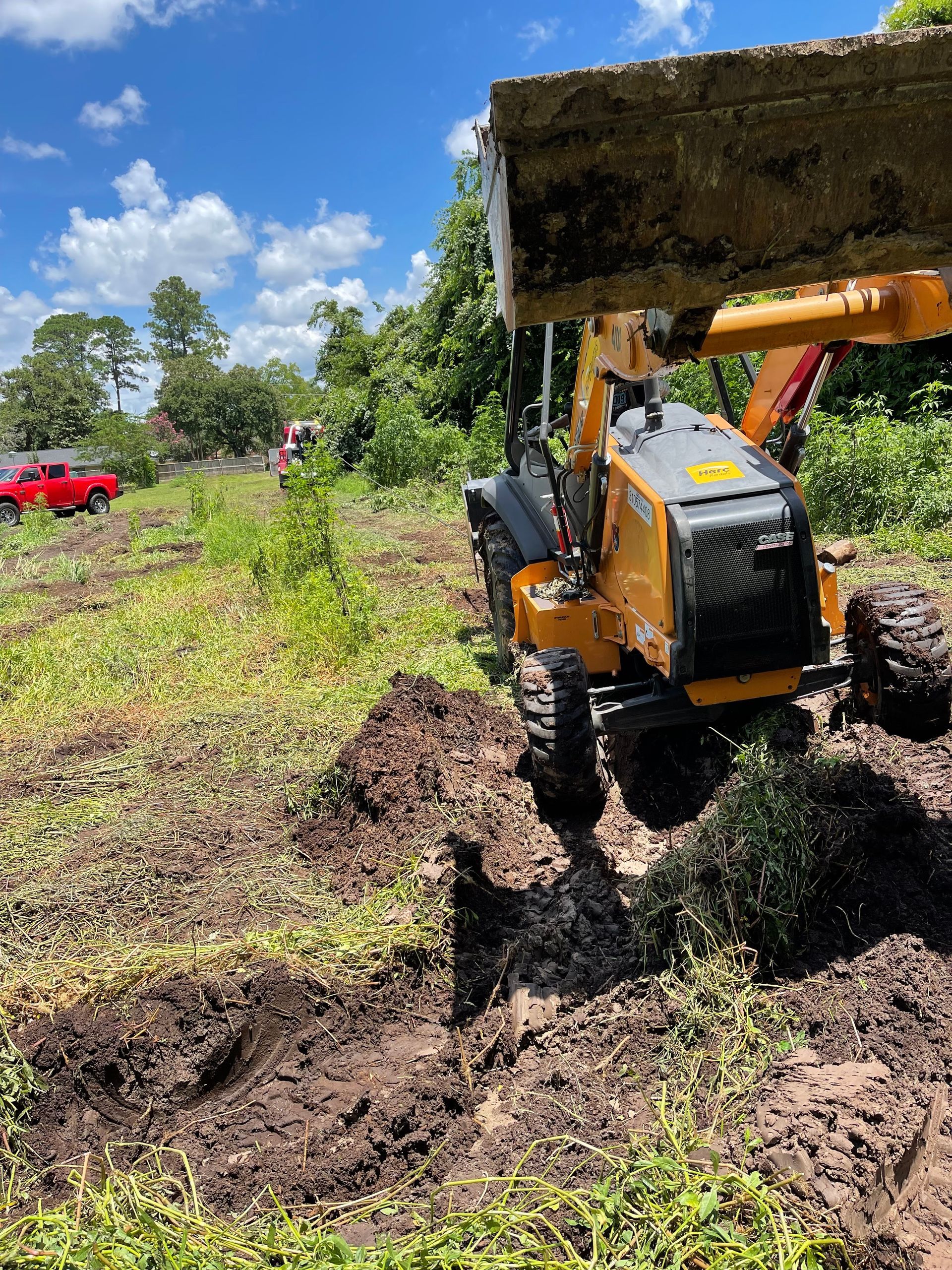 A bulldozer is digging a hole in the dirt in a field.