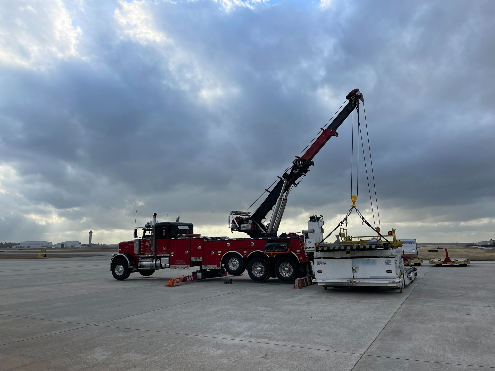 A red tow truck with a crane attached to it