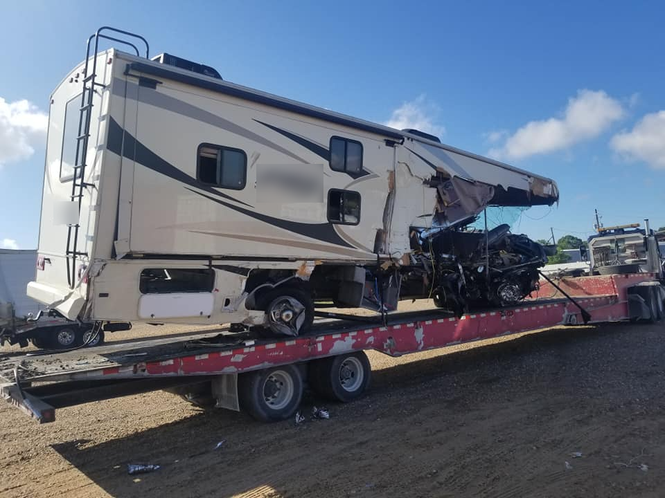 A semi truck is carrying a large dump truck on a trailer.