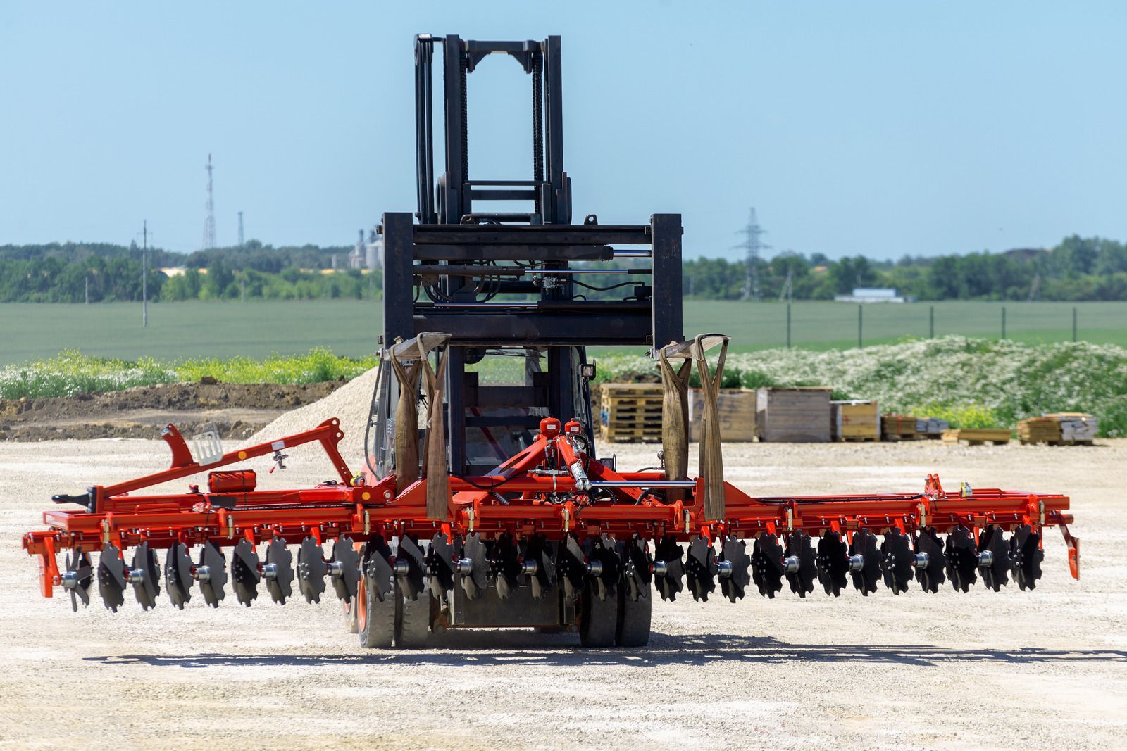 A forklift is carrying a large red and black machine