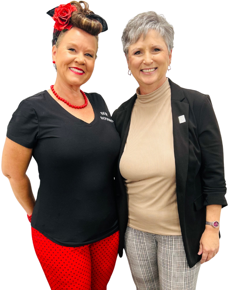 Man and woman in aprons smiling, looking at a tablet.