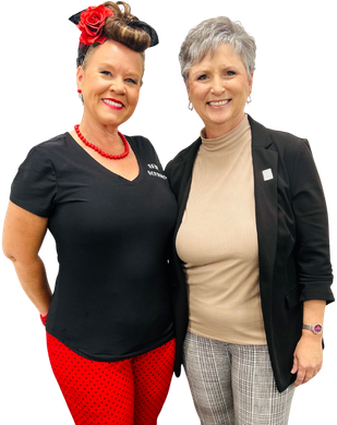 Man and woman in aprons smiling, looking at a tablet.