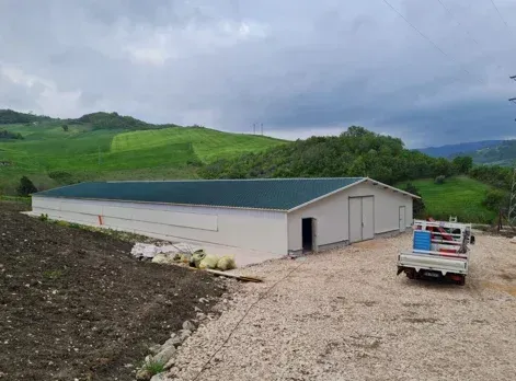 Un camion è parcheggiato davanti a un grande edificio bianco con il tetto verde.