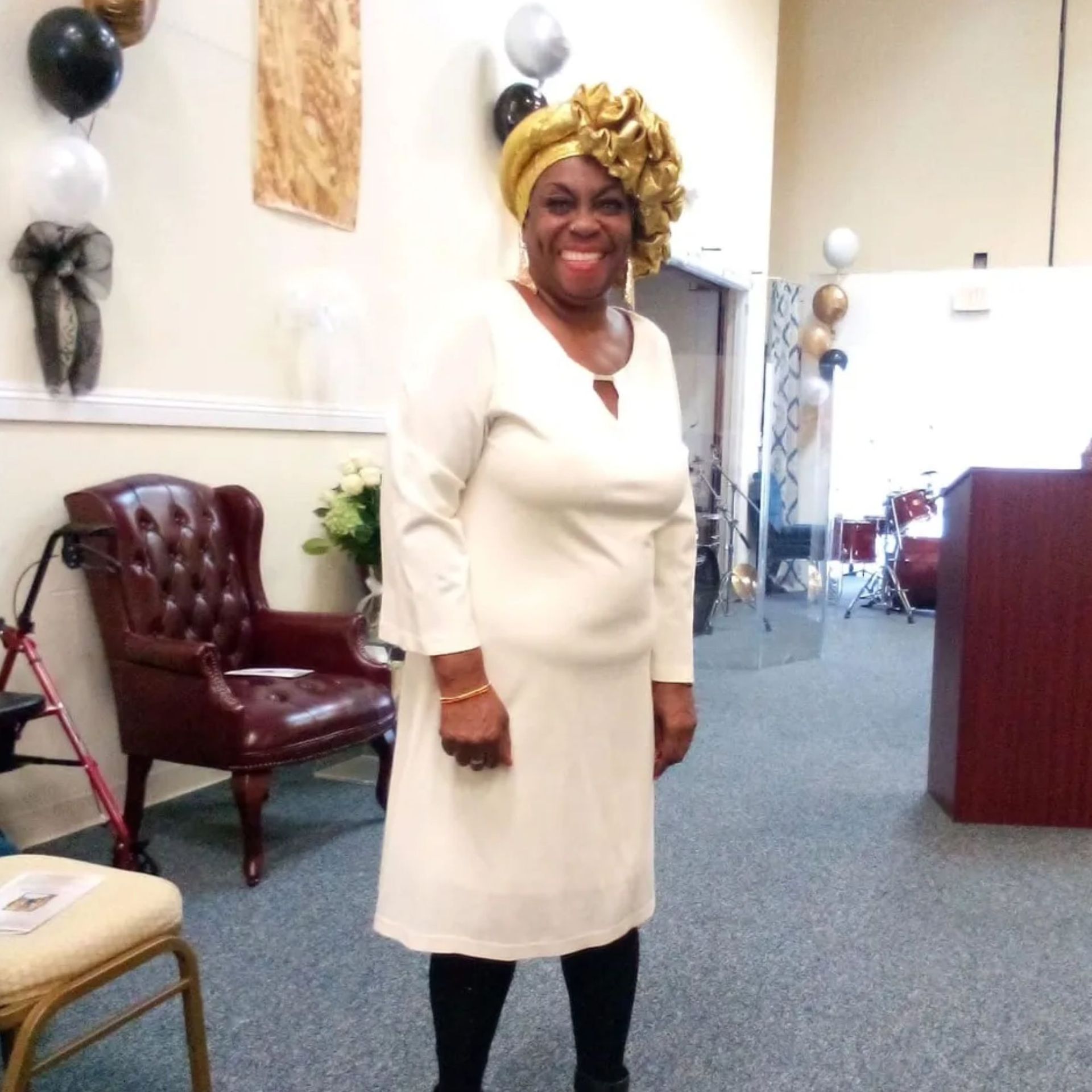 A woman in a white dress with a turban on her head