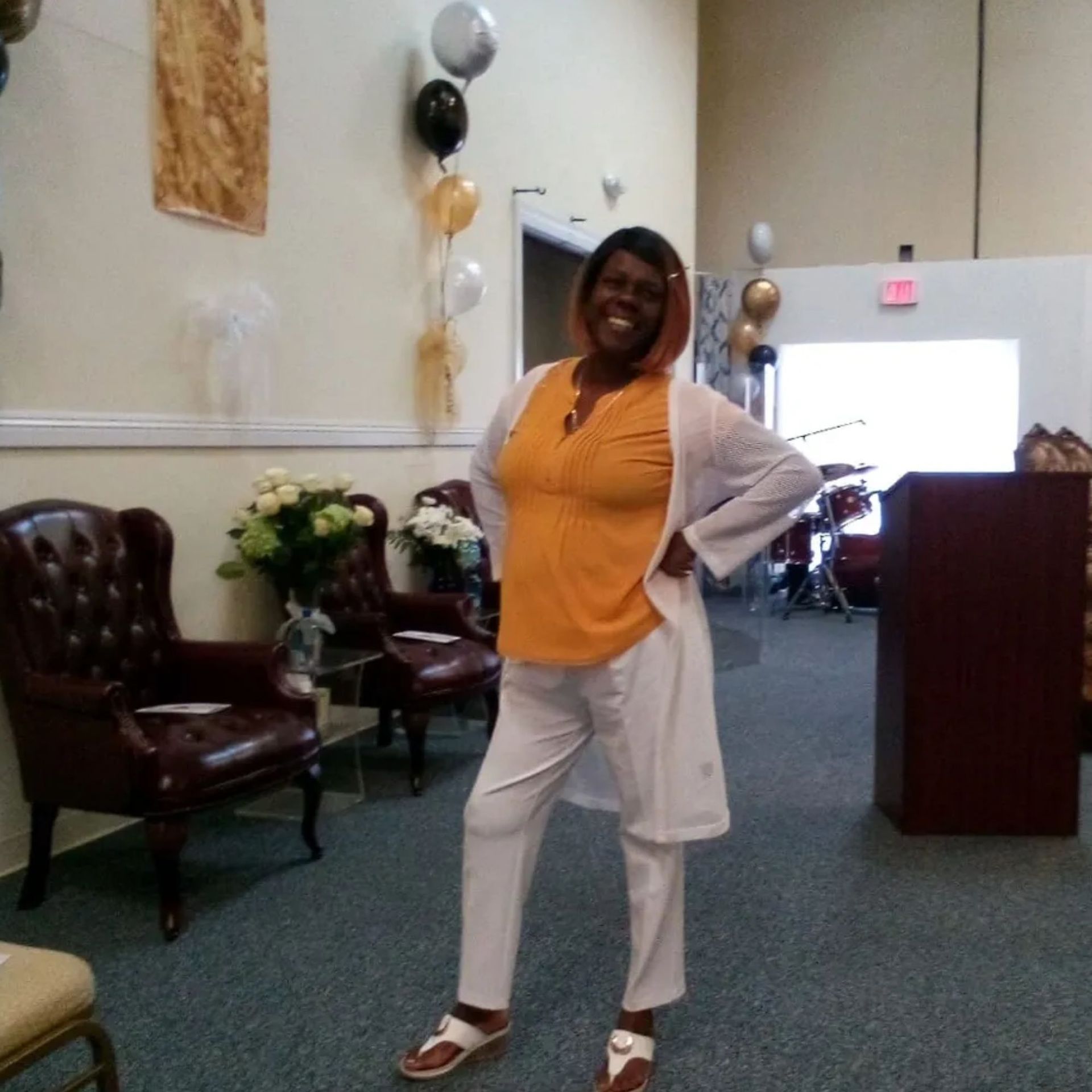 A woman standing in a room with balloons on the wall
