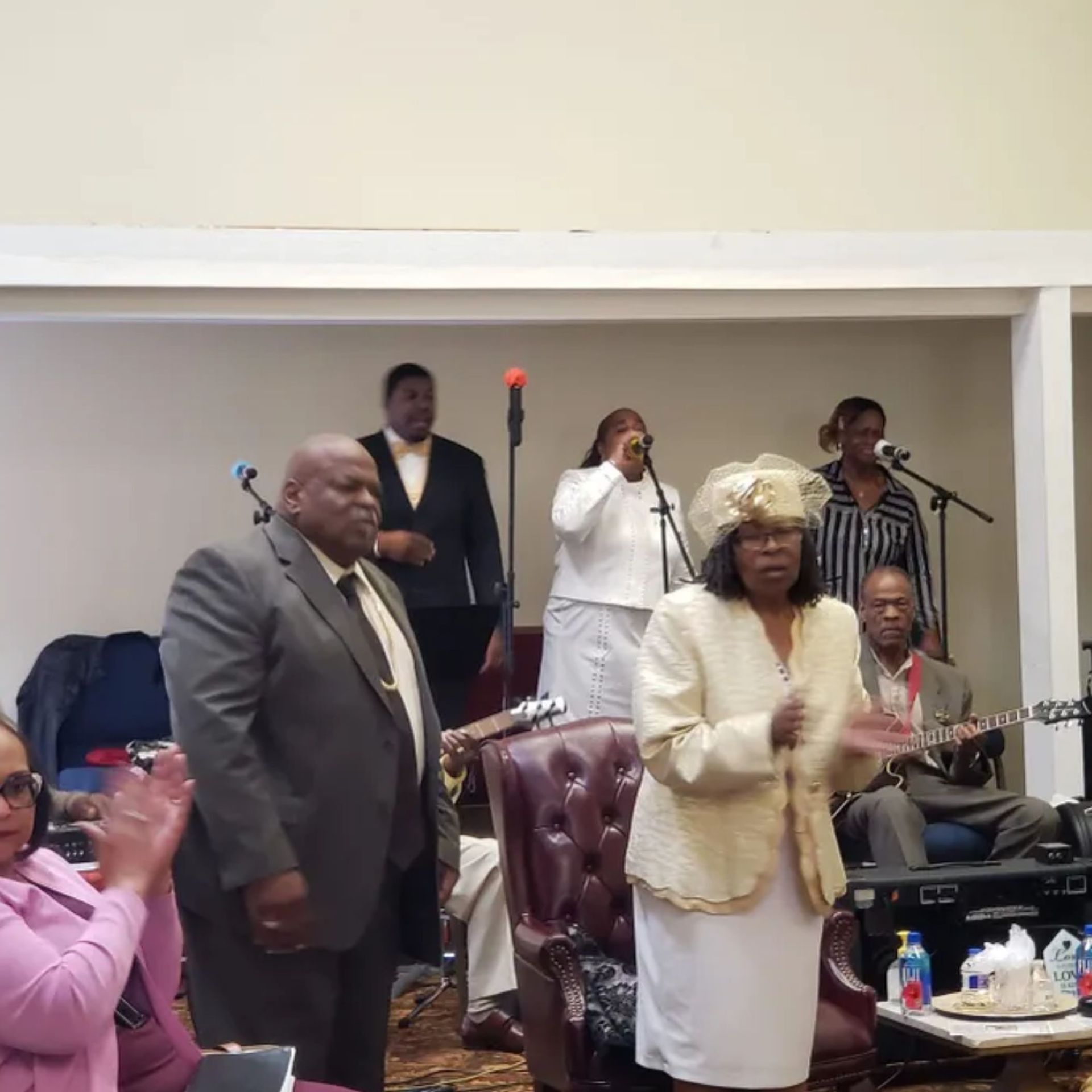 A group of people standing in a room with microphones