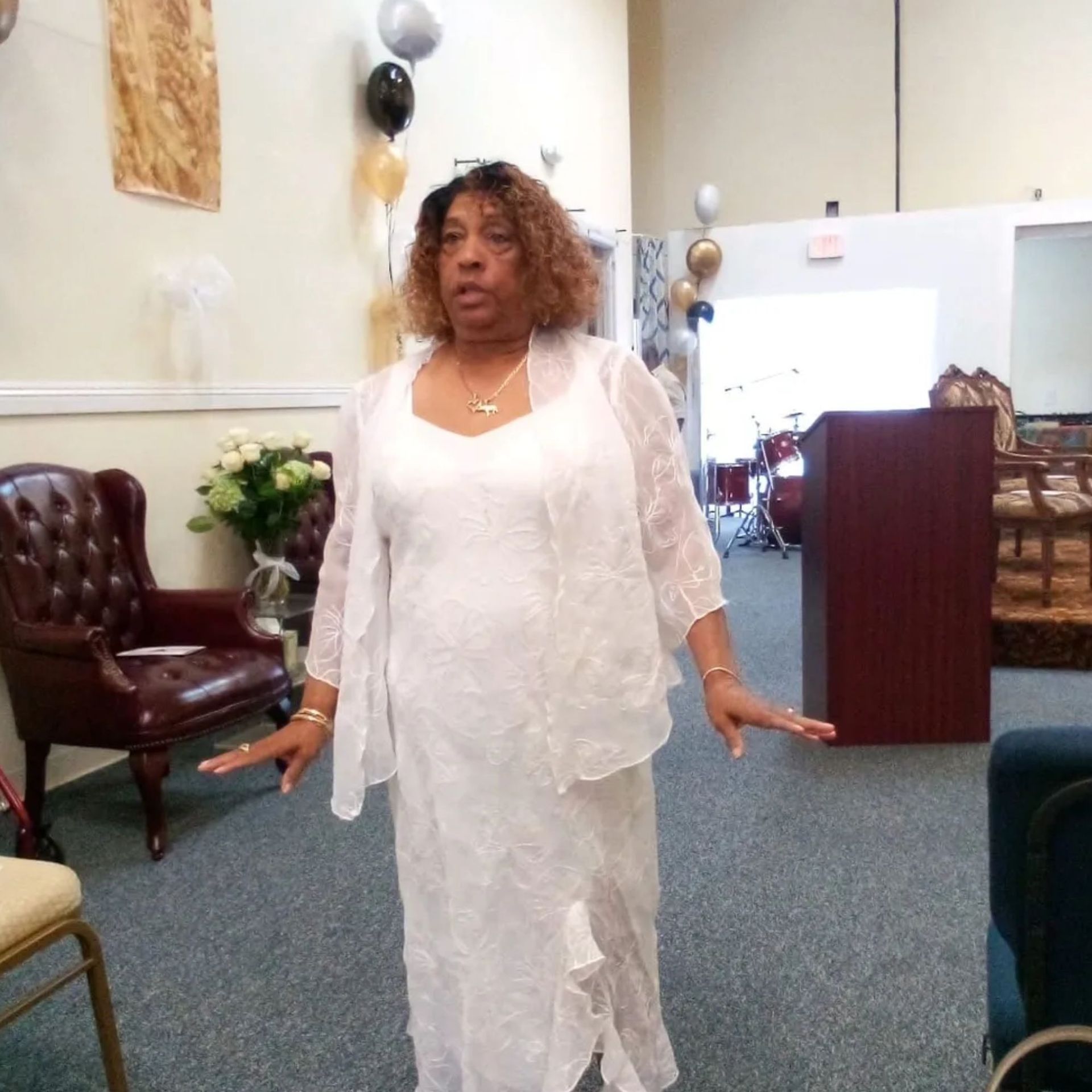A woman in a white dress is standing in a room