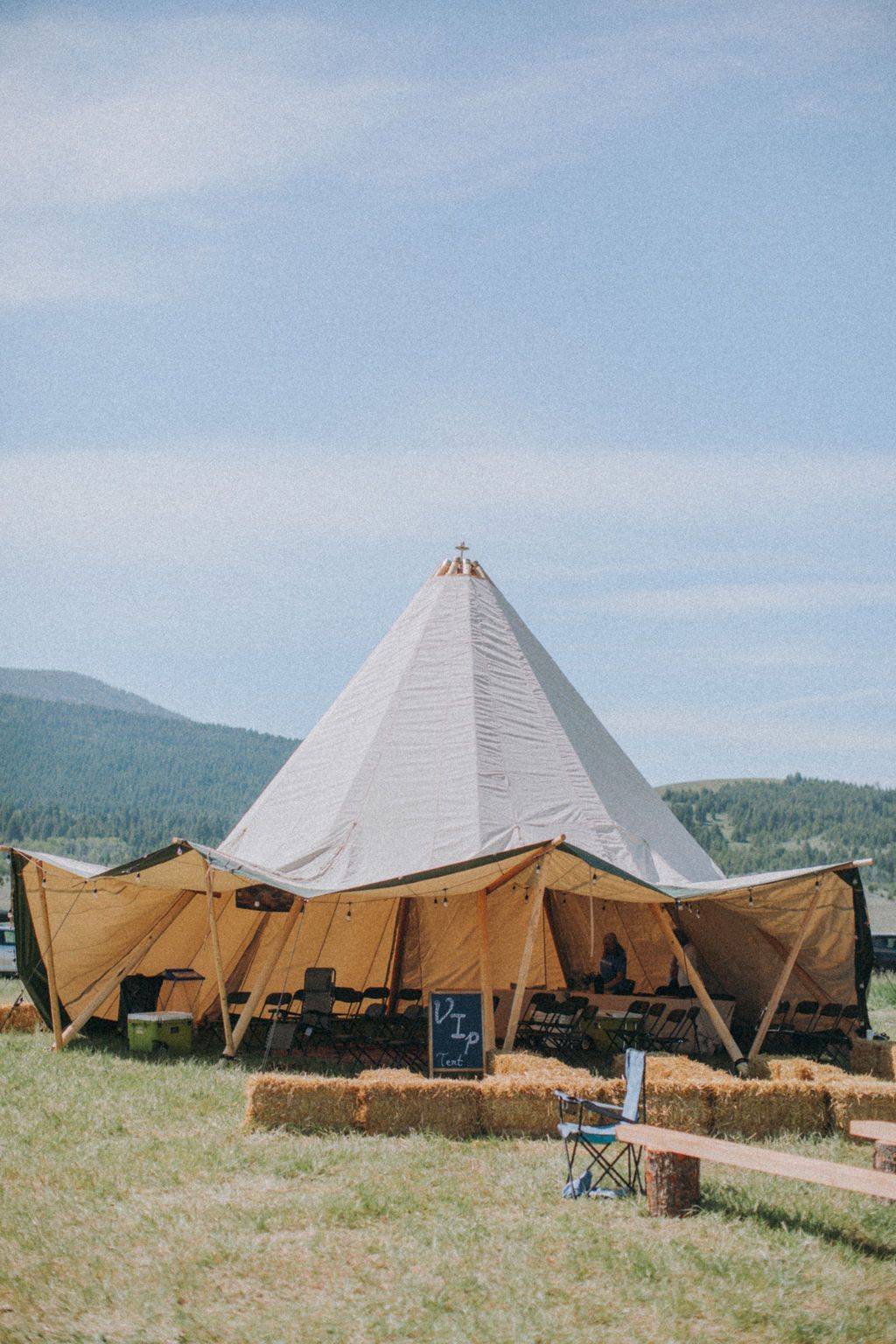 A large tent is sitting in the middle of a grassy field.