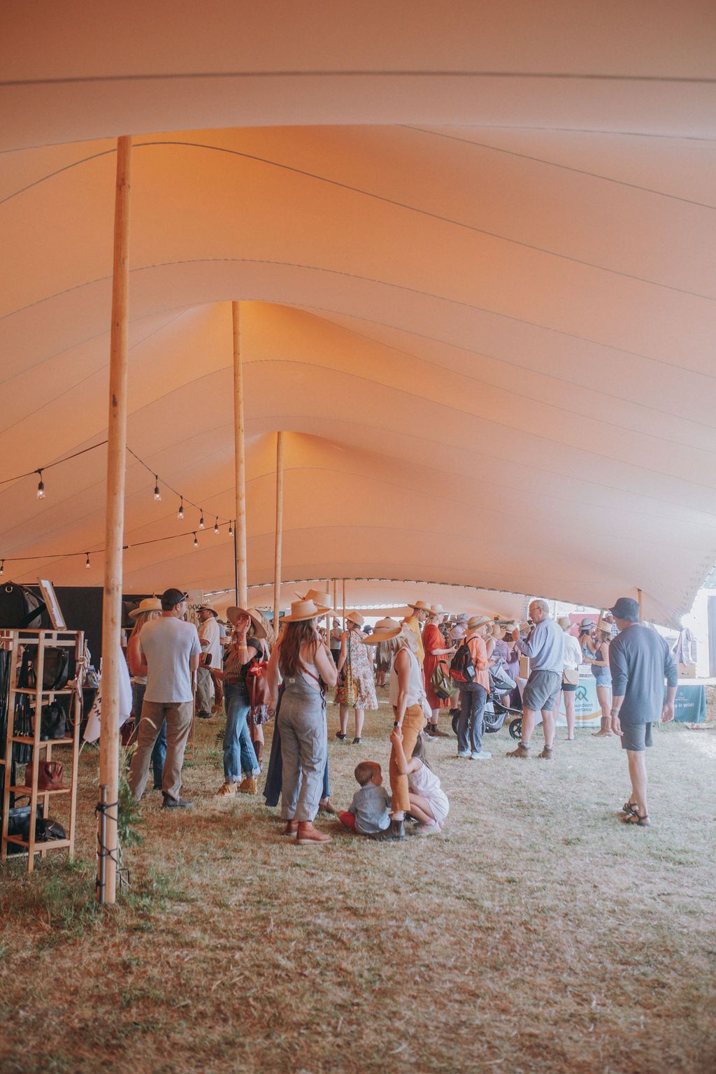 A group of people are standing under a tent at a festival.