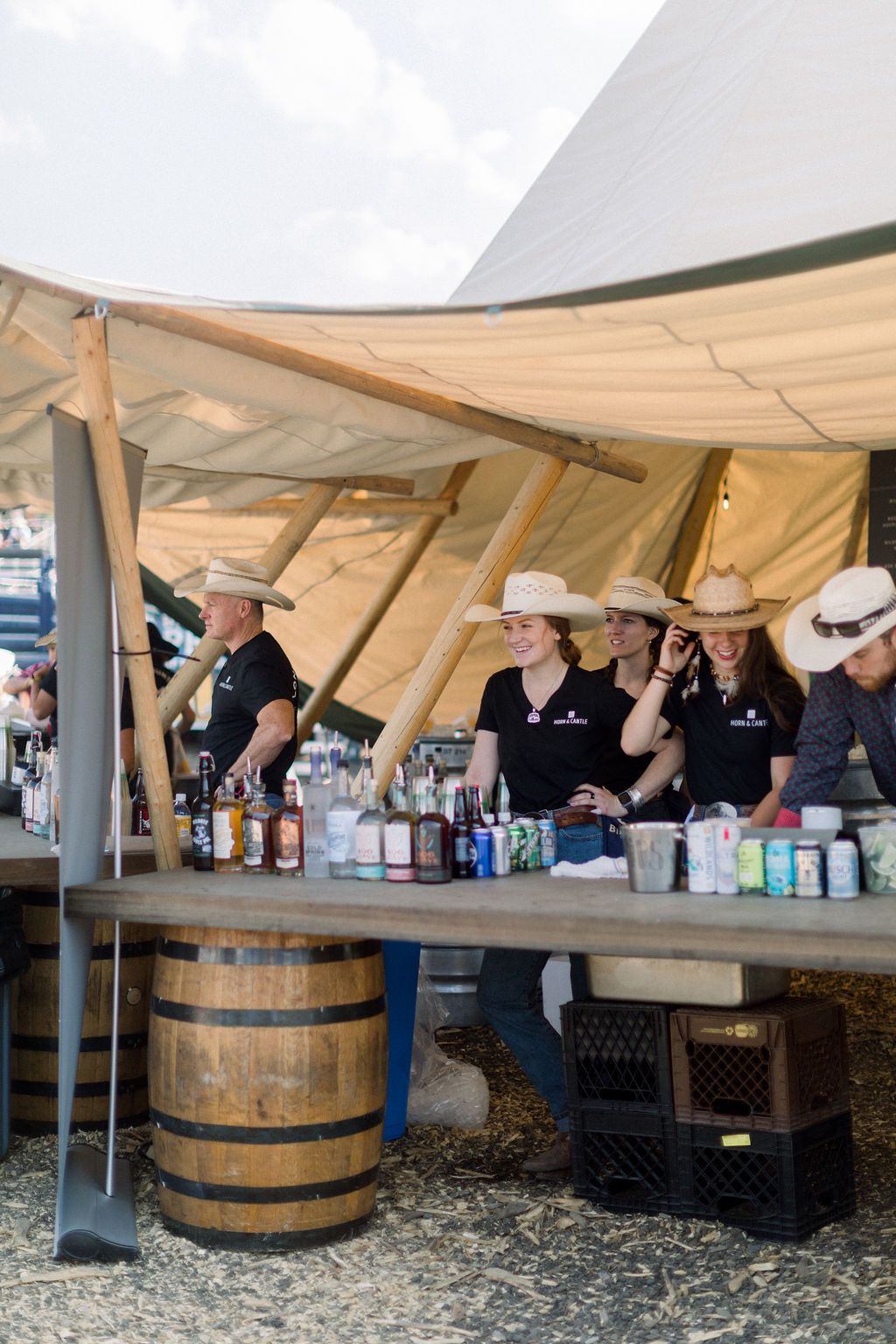 A group of people wearing cowboy hats are standing around a table.