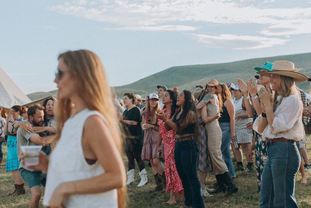 A woman is standing in front of a crowd of people at a festival.
