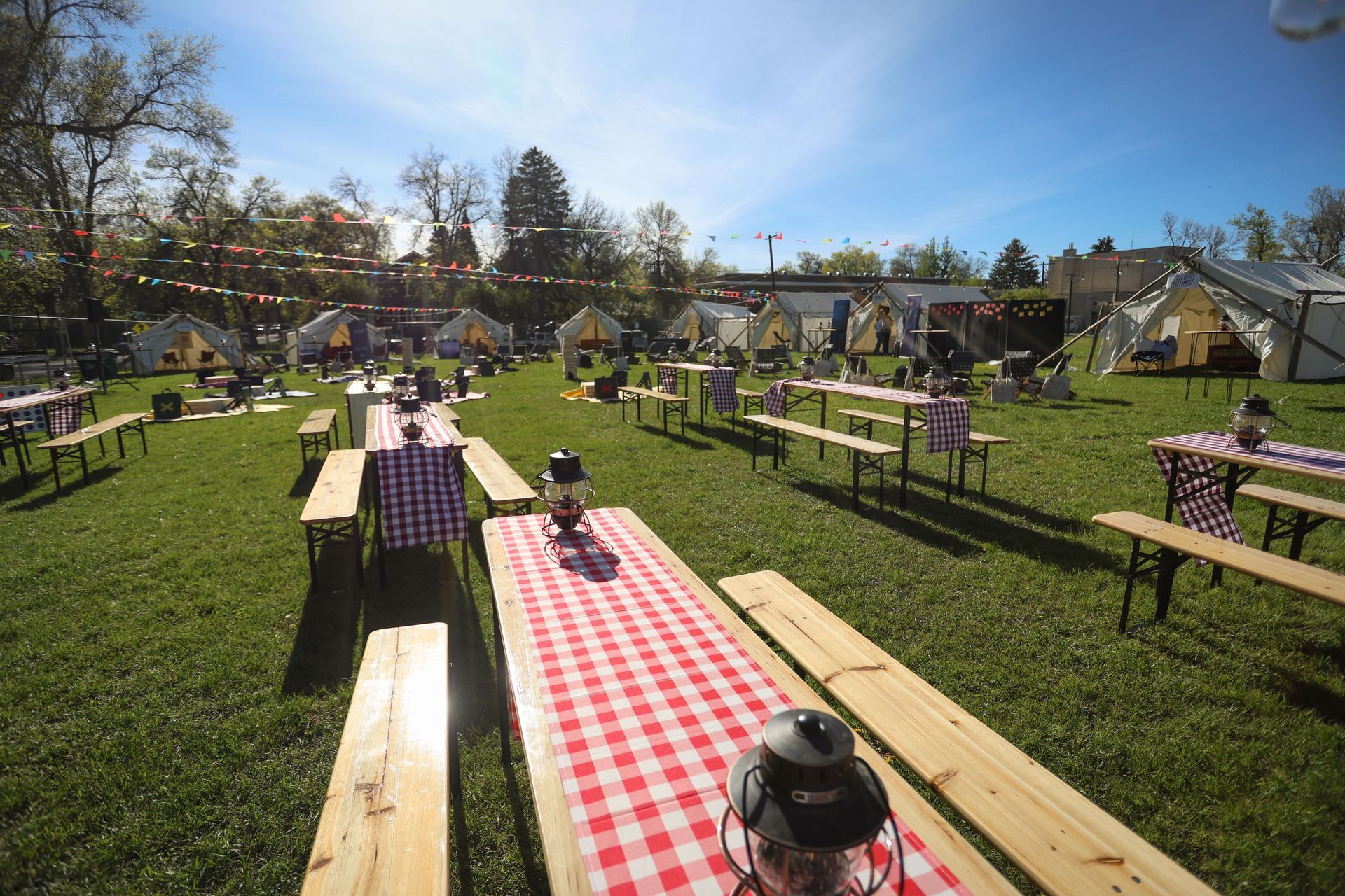 A field with tables and benches set up for a picnic