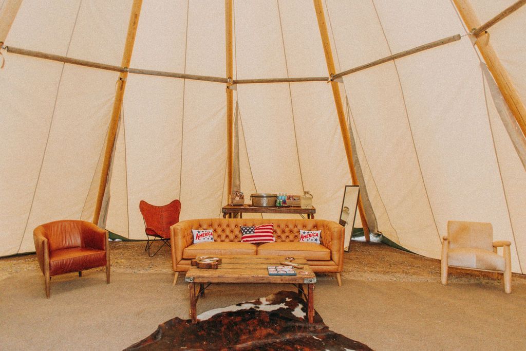 A living room in a teepee with a couch and chairs