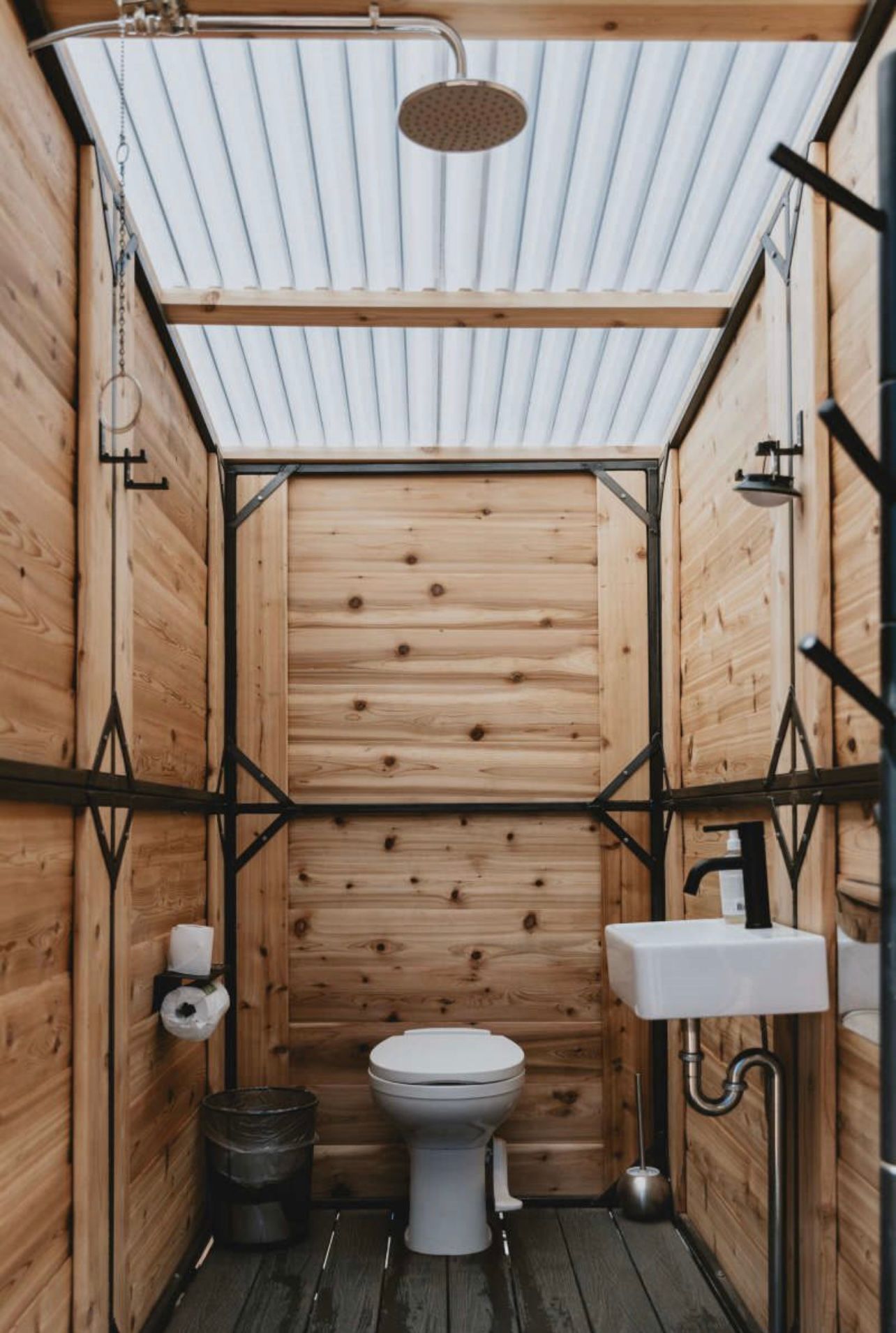 A bathroom with a toilet , sink and shower.