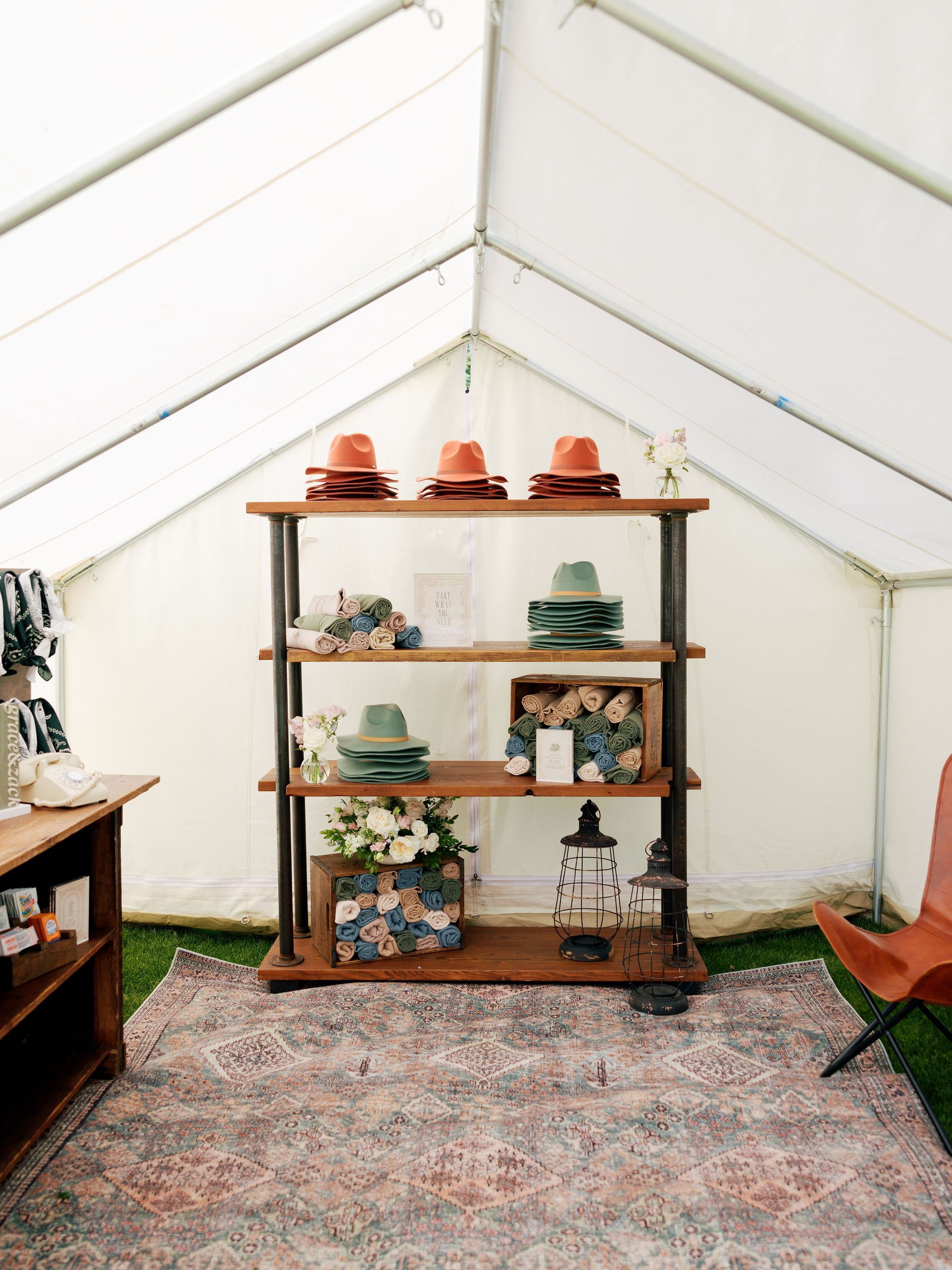 There is a shelf with hats on it in a tent.