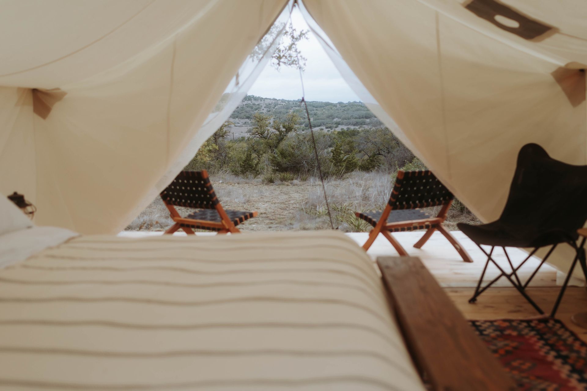 A tent with a bed and chairs inside of it