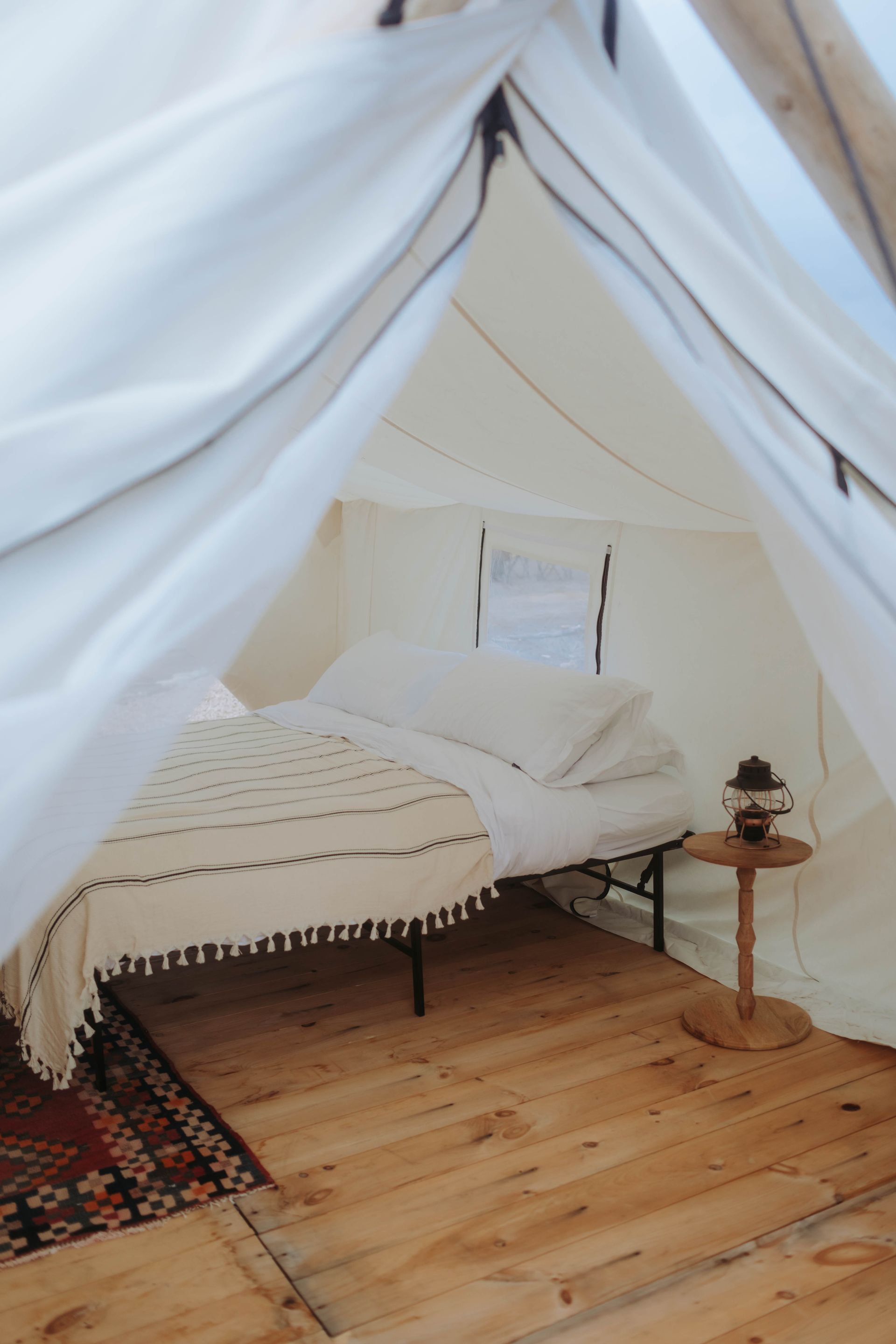 A tent with a bed and a table inside of it