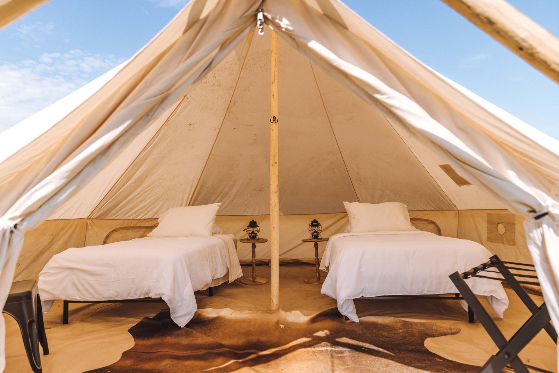 A tent with two beds and a rug on the floor