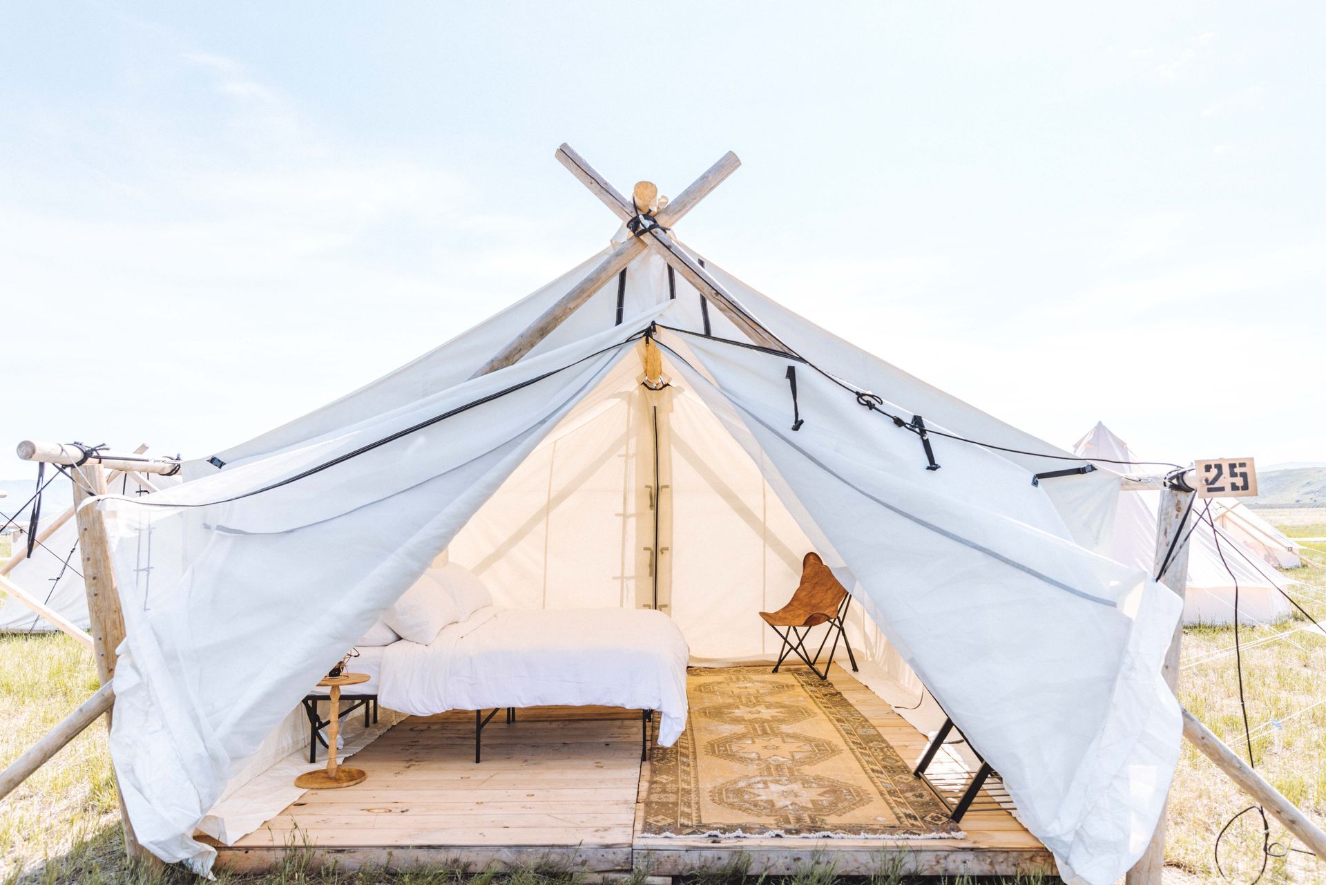 A white tent with a bed inside of it.