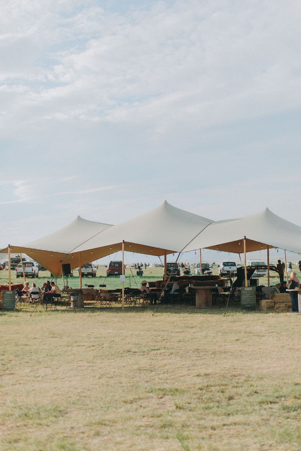 A group of tents are sitting in the middle of a field.
