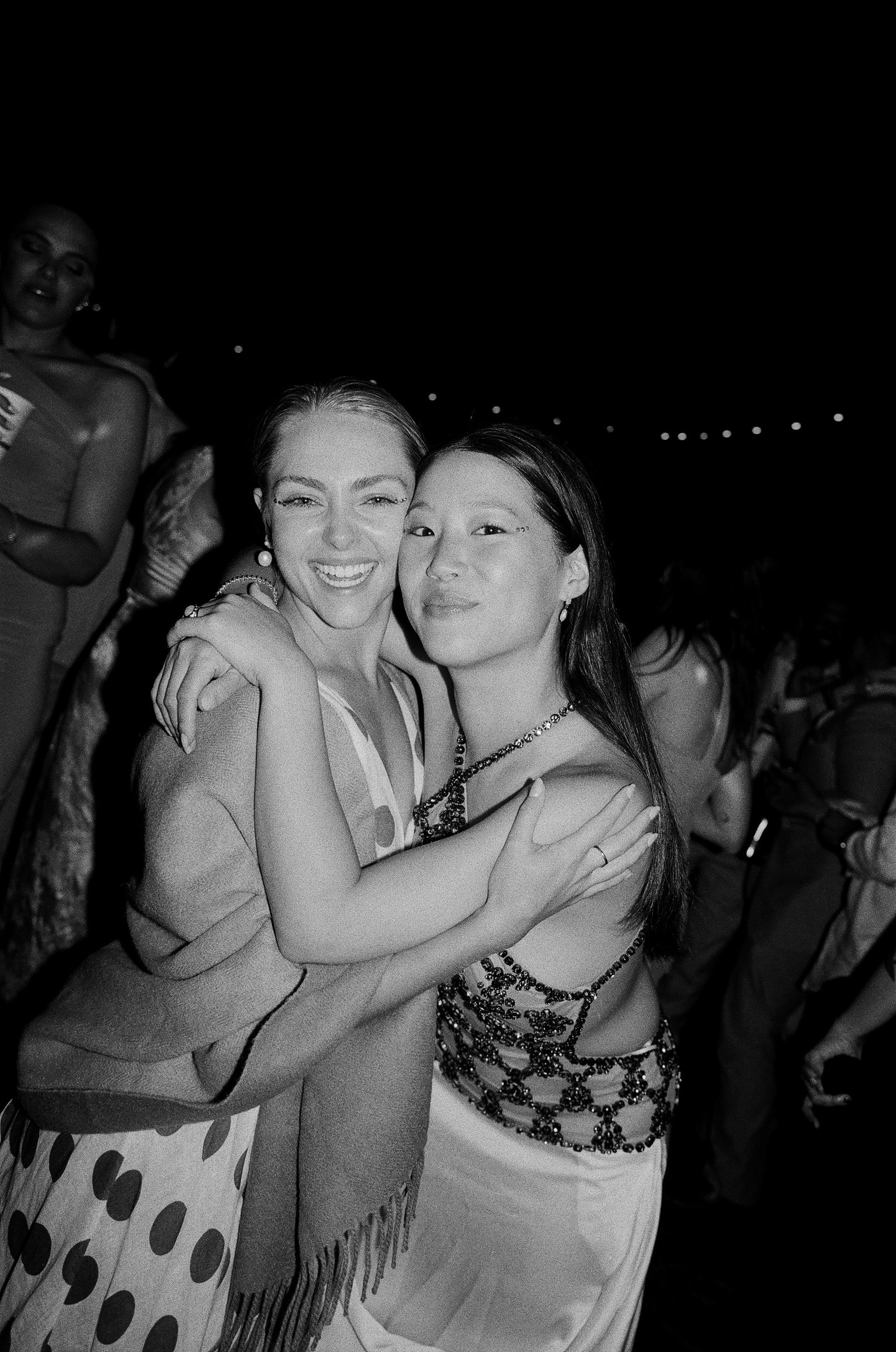 Two women are hugging each other in a black and white photo.