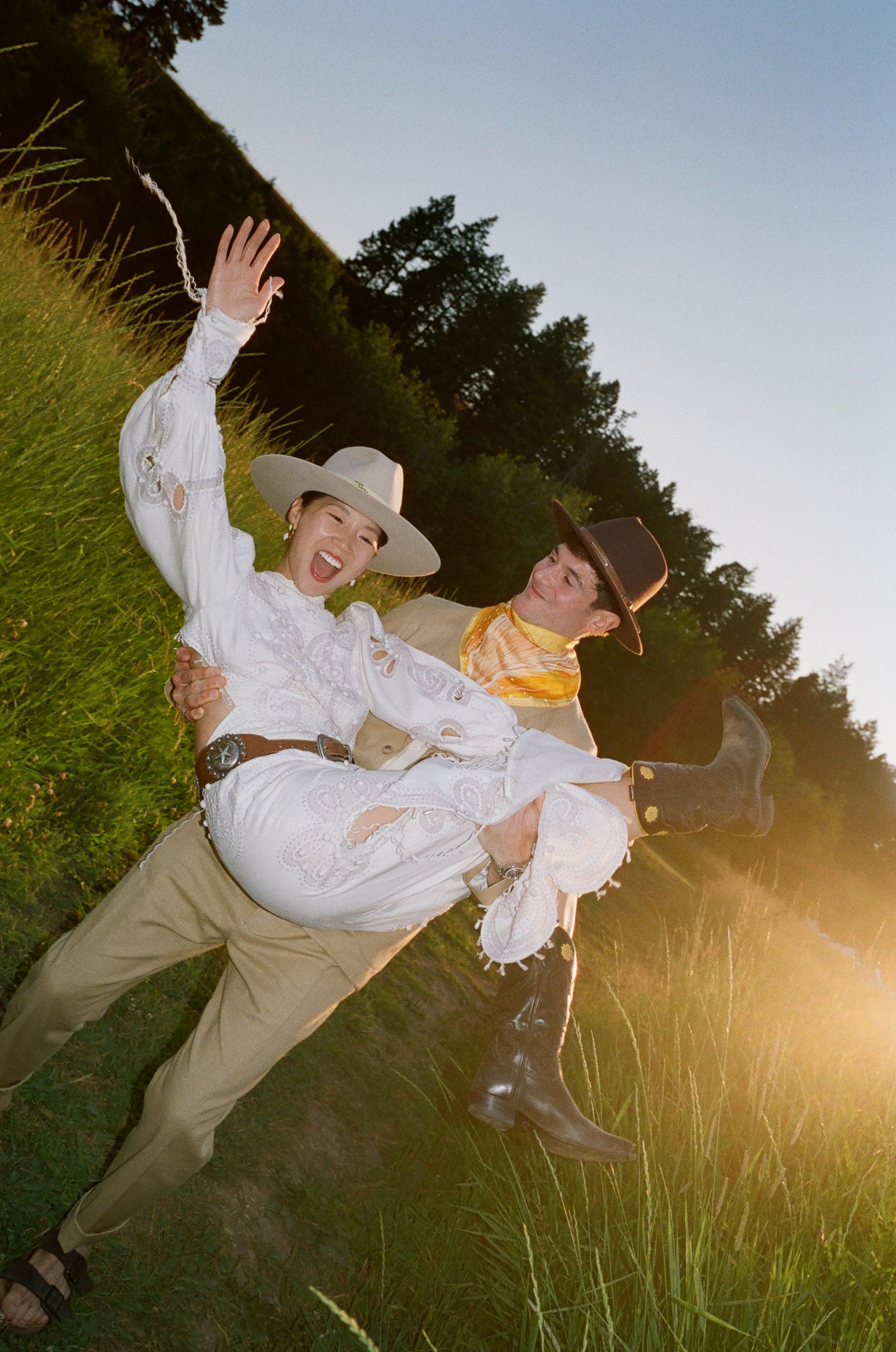 A man is holding a woman in his arms in a field.