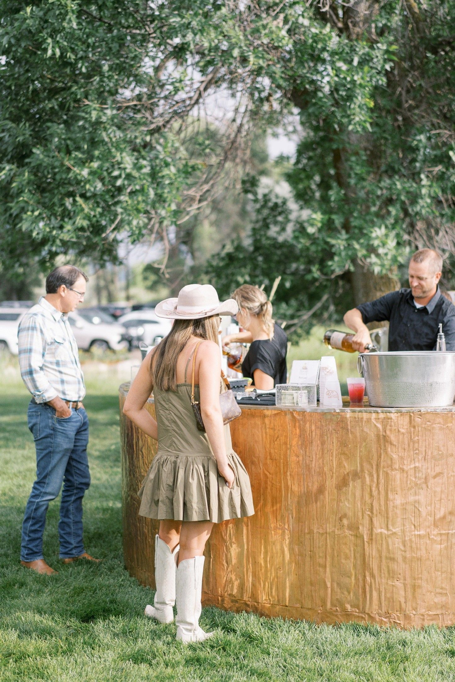 A group of people are standing around a wooden bar.