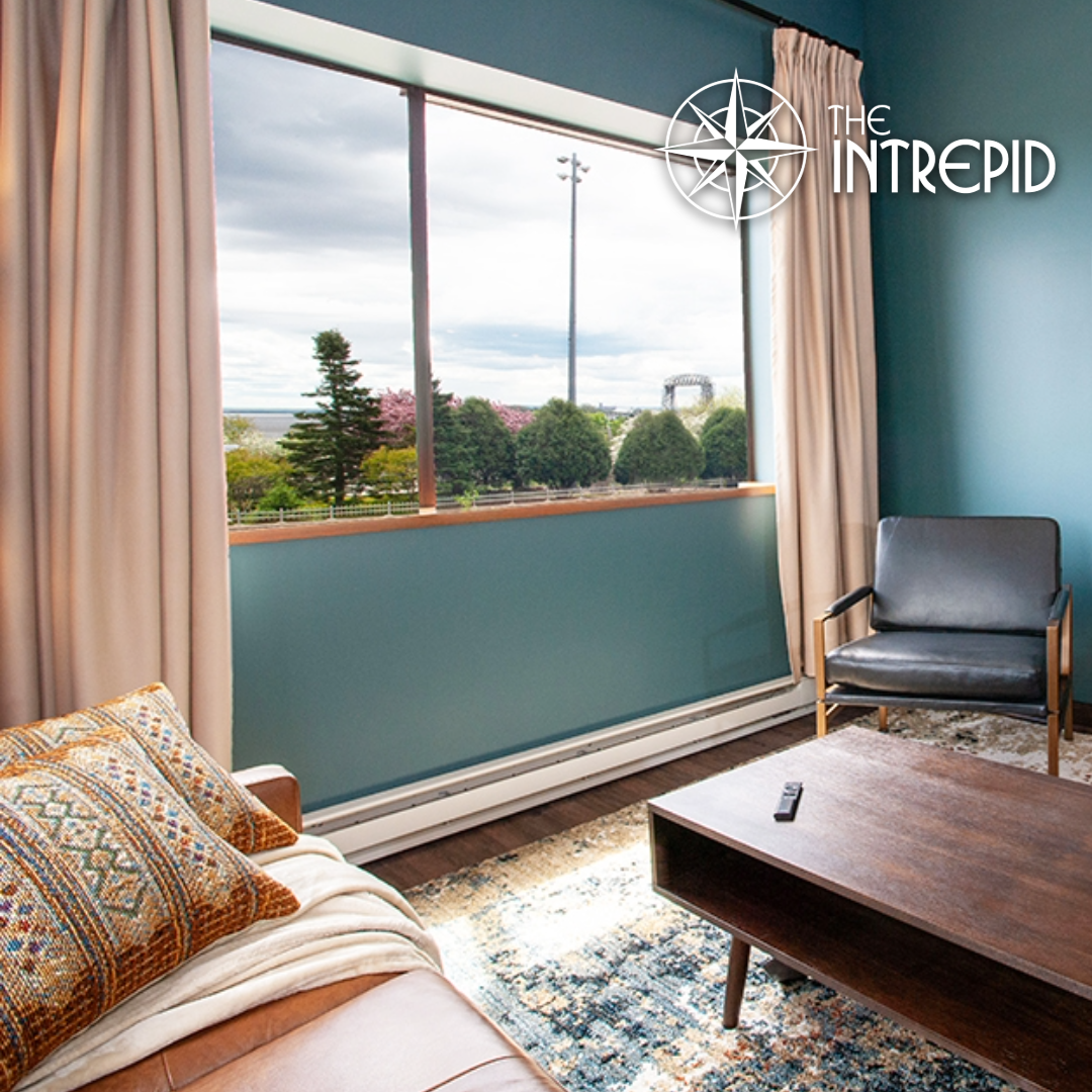 A living room with a couch , chairs , coffee table and television.