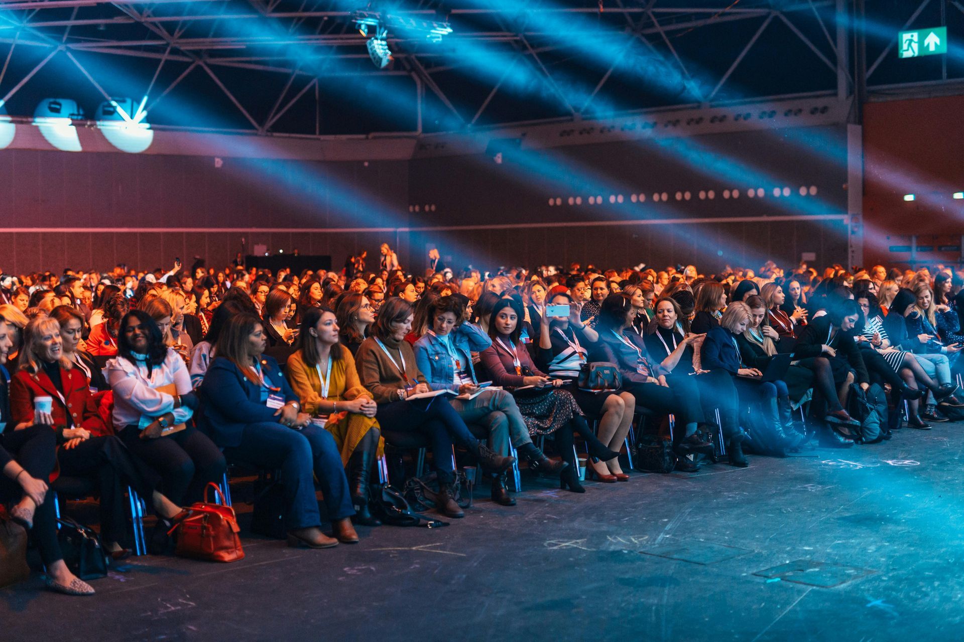 A large group of people are sitting in an auditorium watching a presentation.