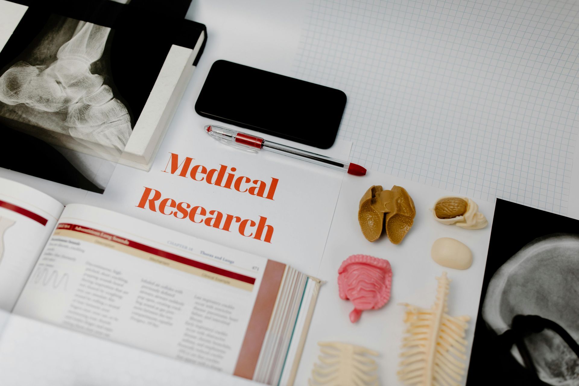 A table with books , a cell phone , and a sign that says medical research