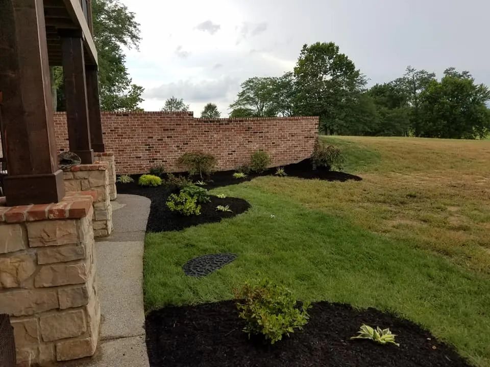 A brick wall is surrounded by a lush green field.