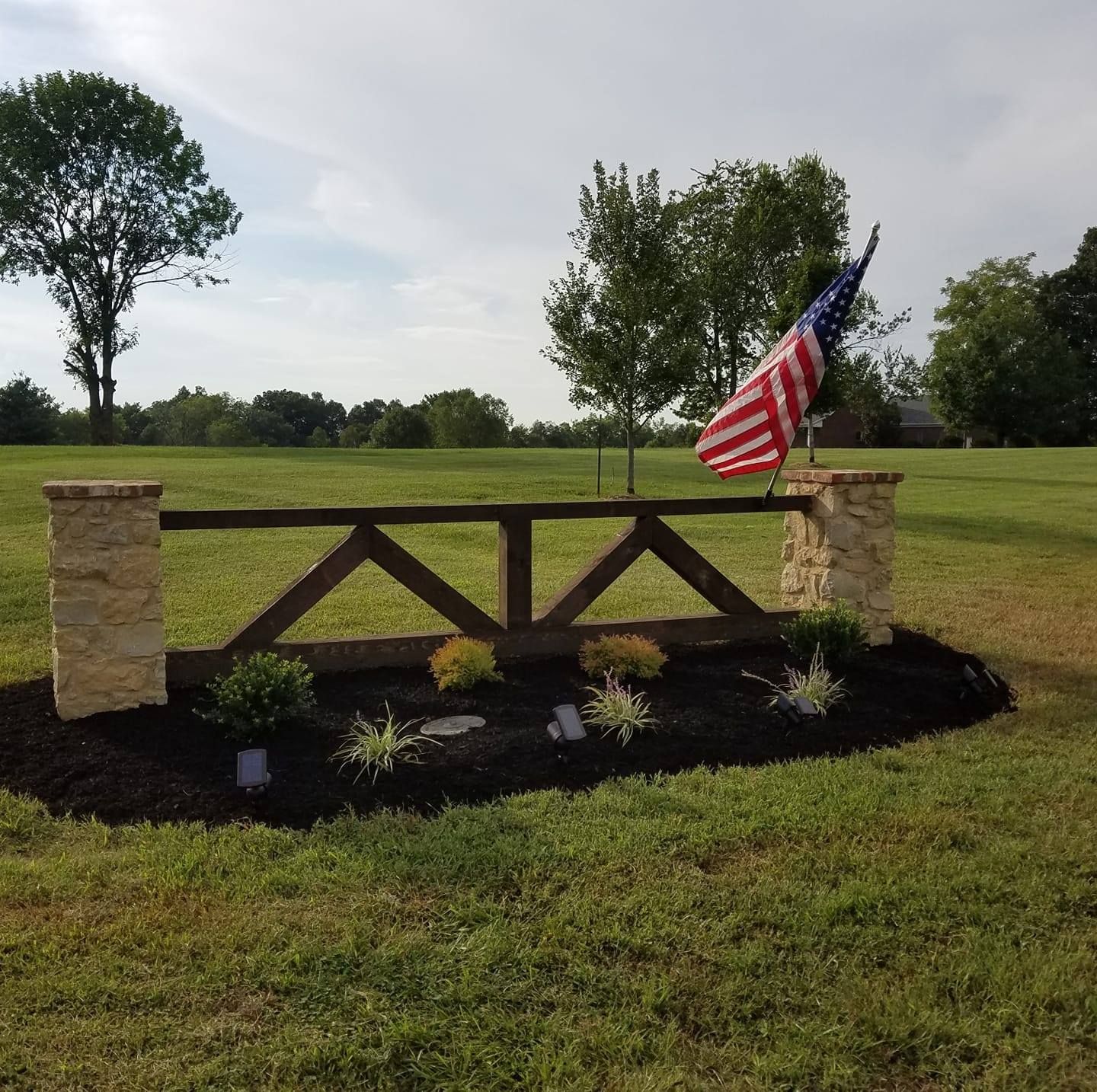 A wooden fence with an american flag on top of it