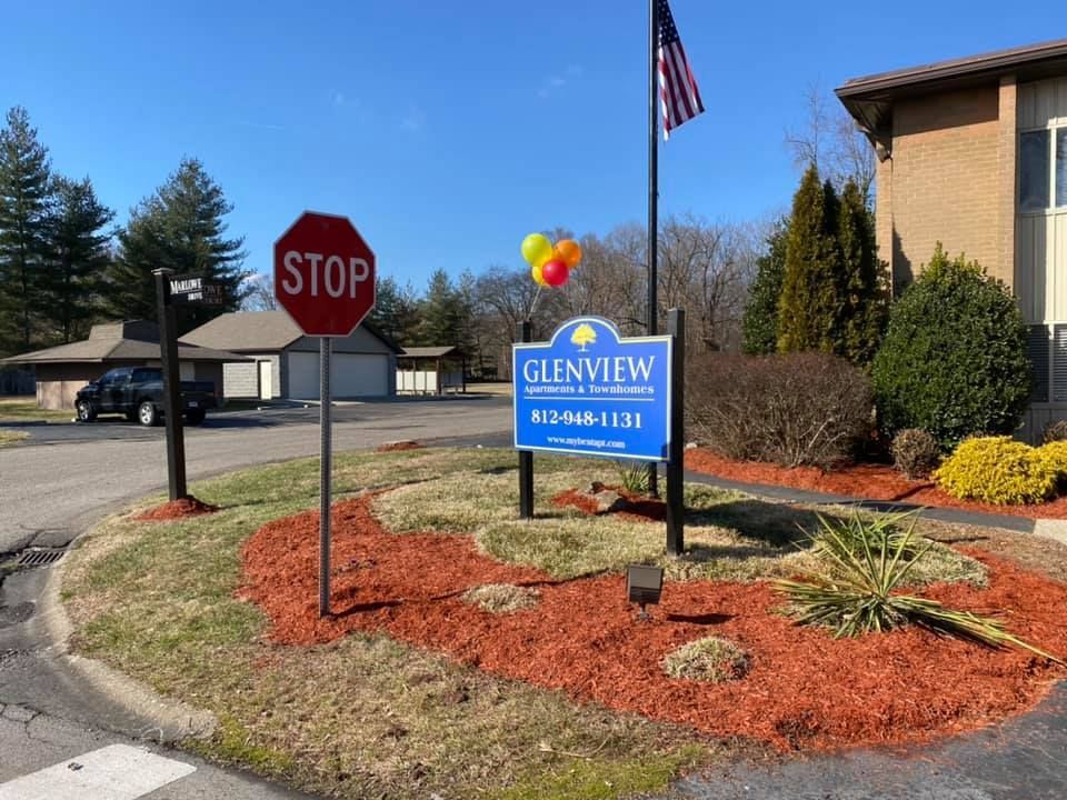 A stop sign and a sign for glenview apartments
