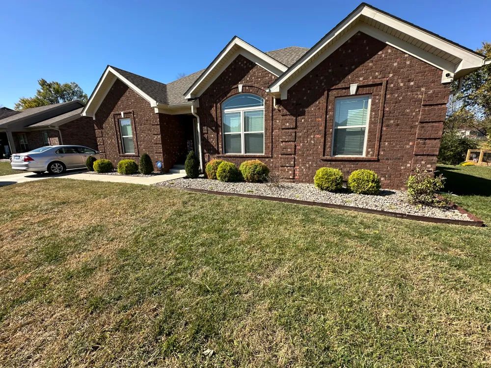 A brick house with a car parked in front of it.