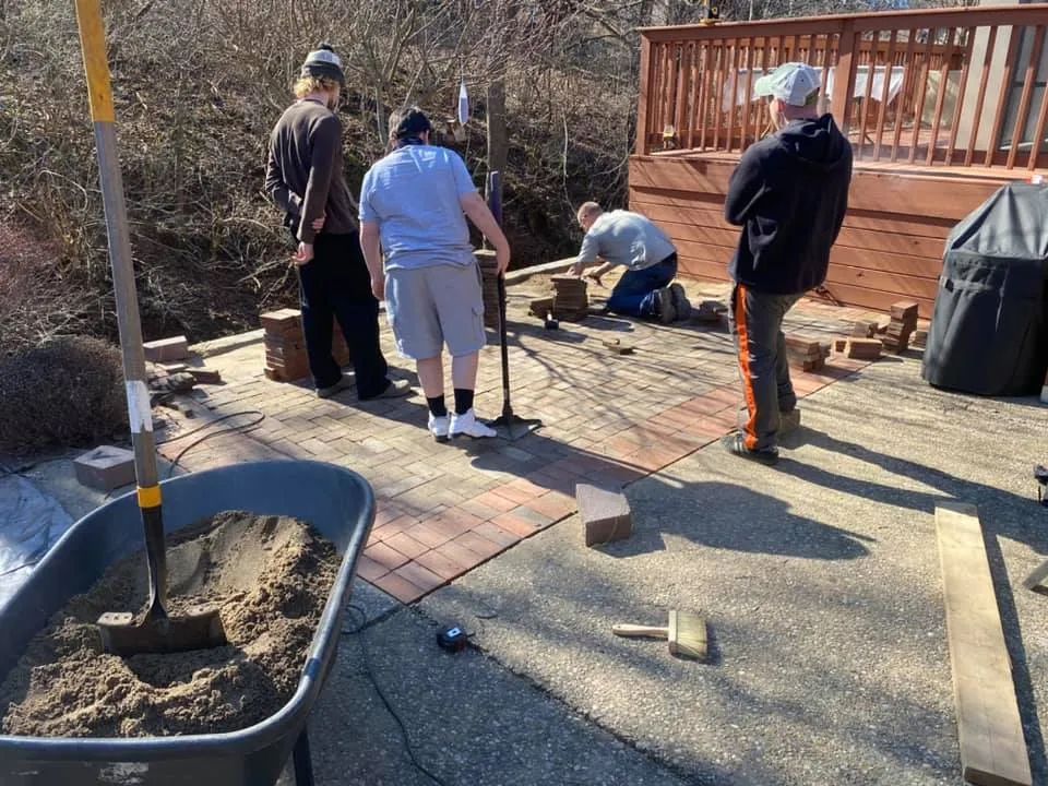 A group of people are working on a patio.
