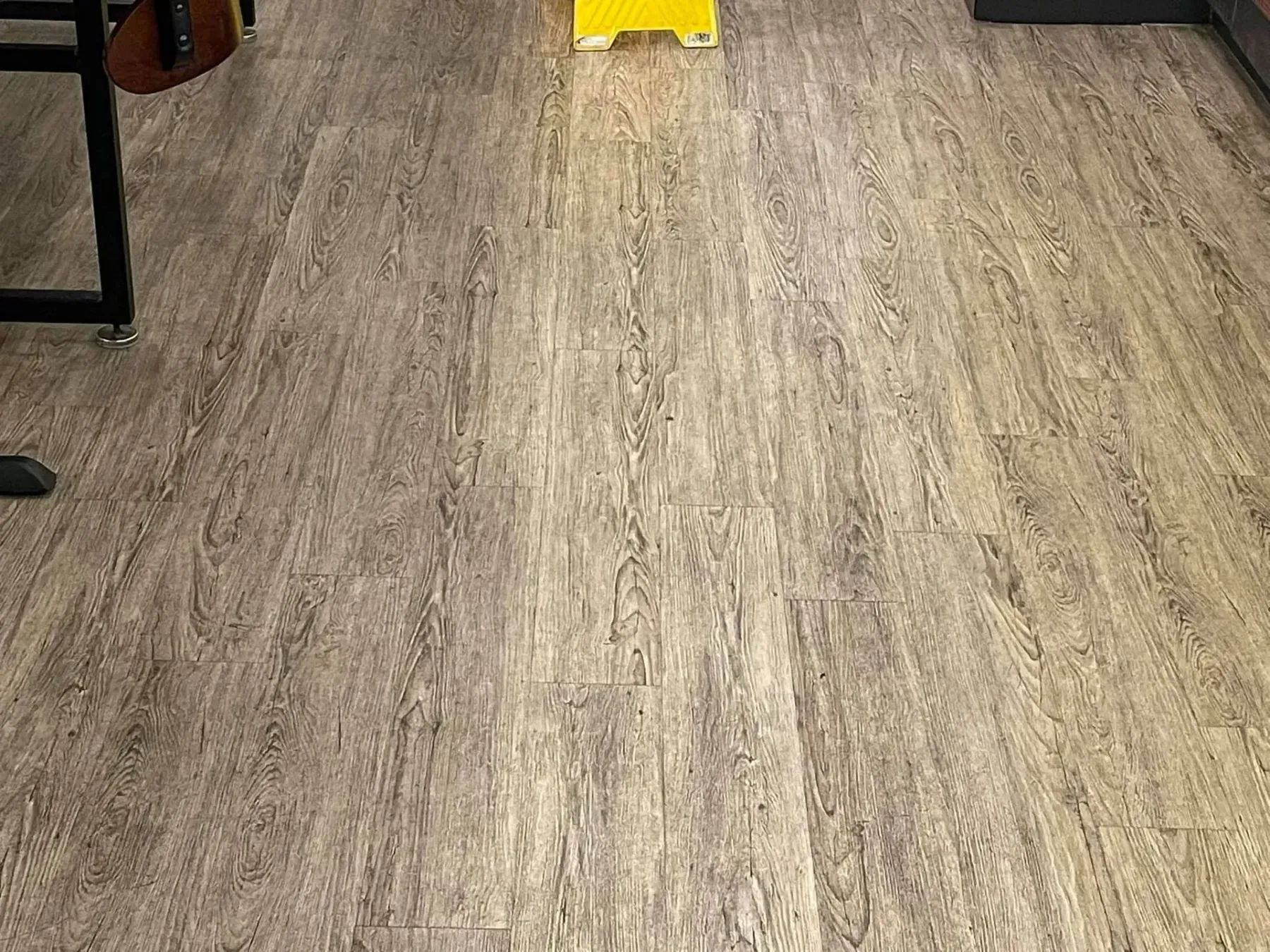 Wood-look flooring in shades of gray and brown. A yellow