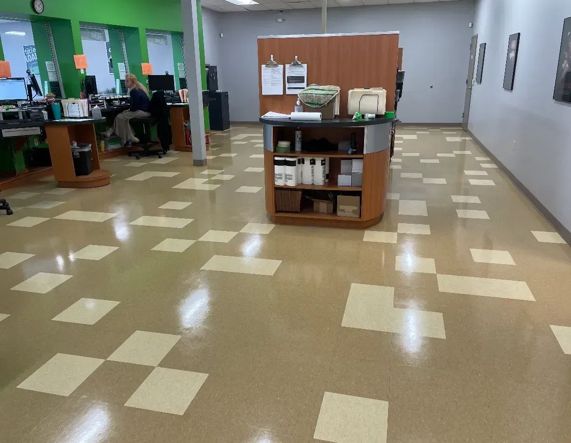 Hair salon interior with tiled floor, central display, and stylists working.