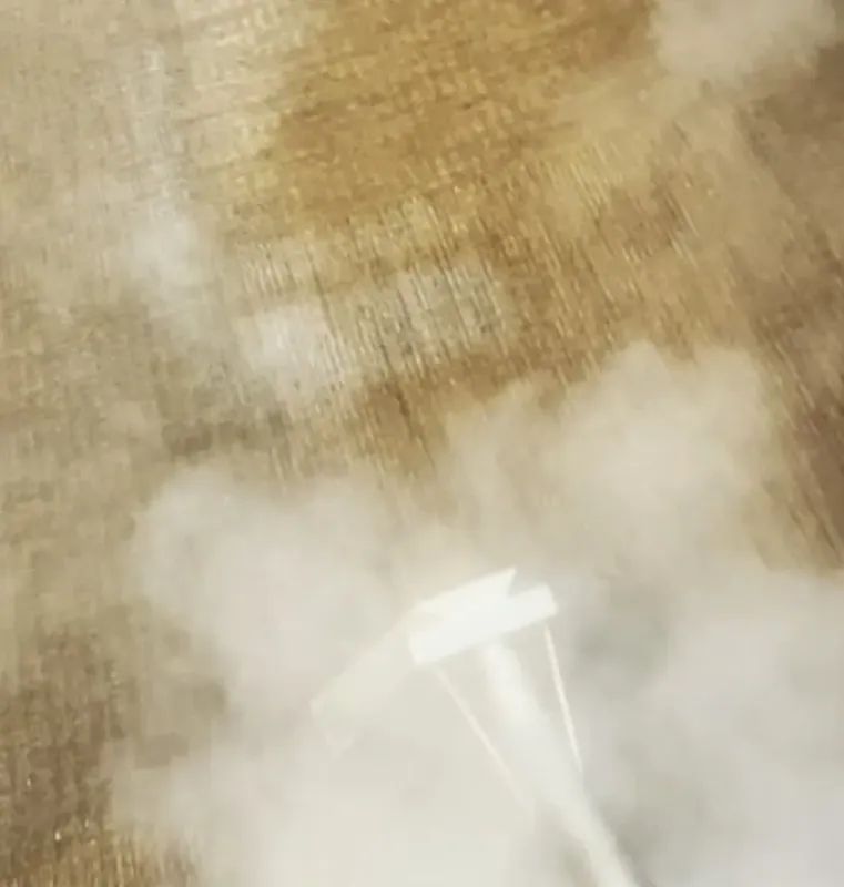Steam cleaning wooden floor. Steam billows around the cleaner head.