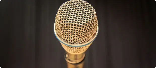 Gold microphone against a dark backdrop.