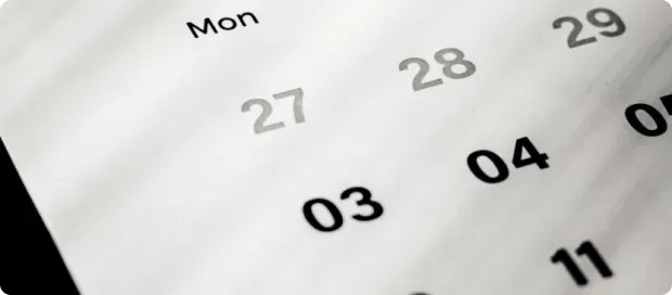 Close-up of a calendar page showing the days of the week and dates 27, 28, 29, 03, 04, and 11.