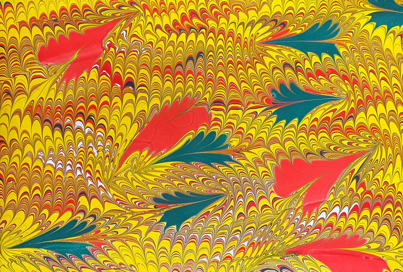 A fine leaf design with cascade combwork in green, red, and yellows.