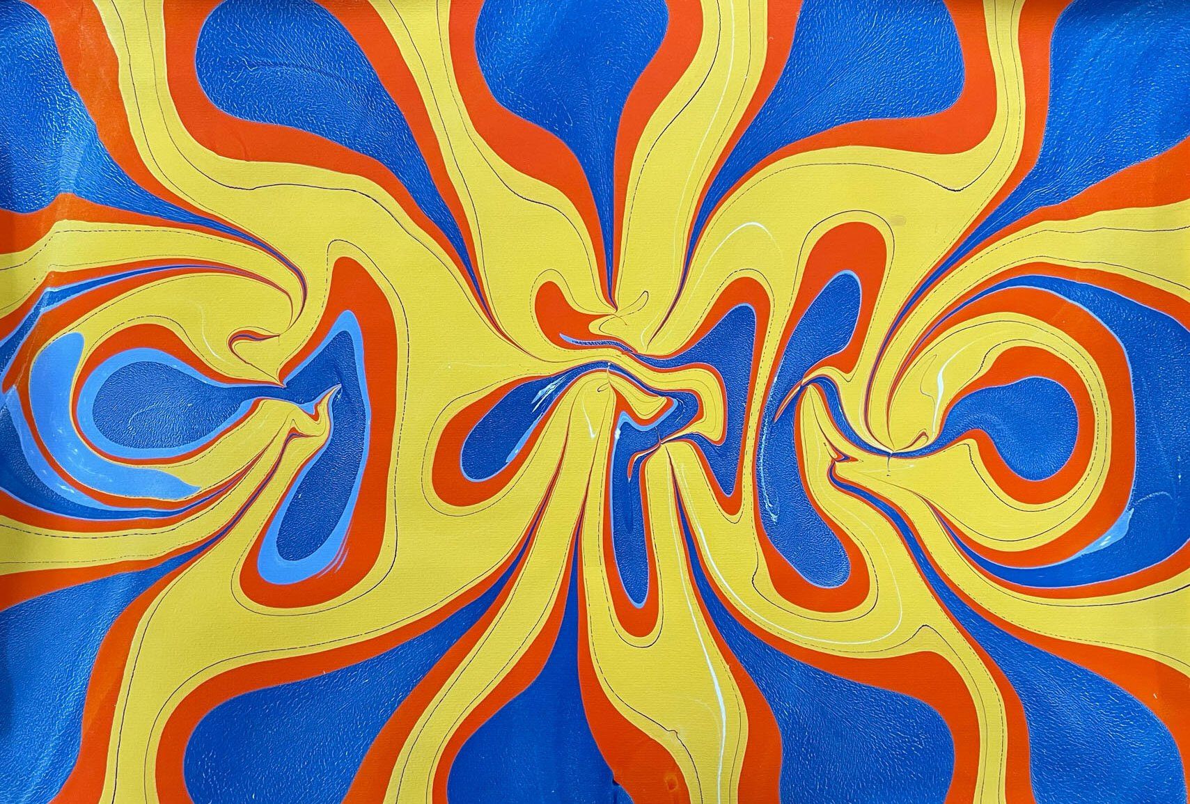 Squish effect in marbled paper with yellow orange and blue.